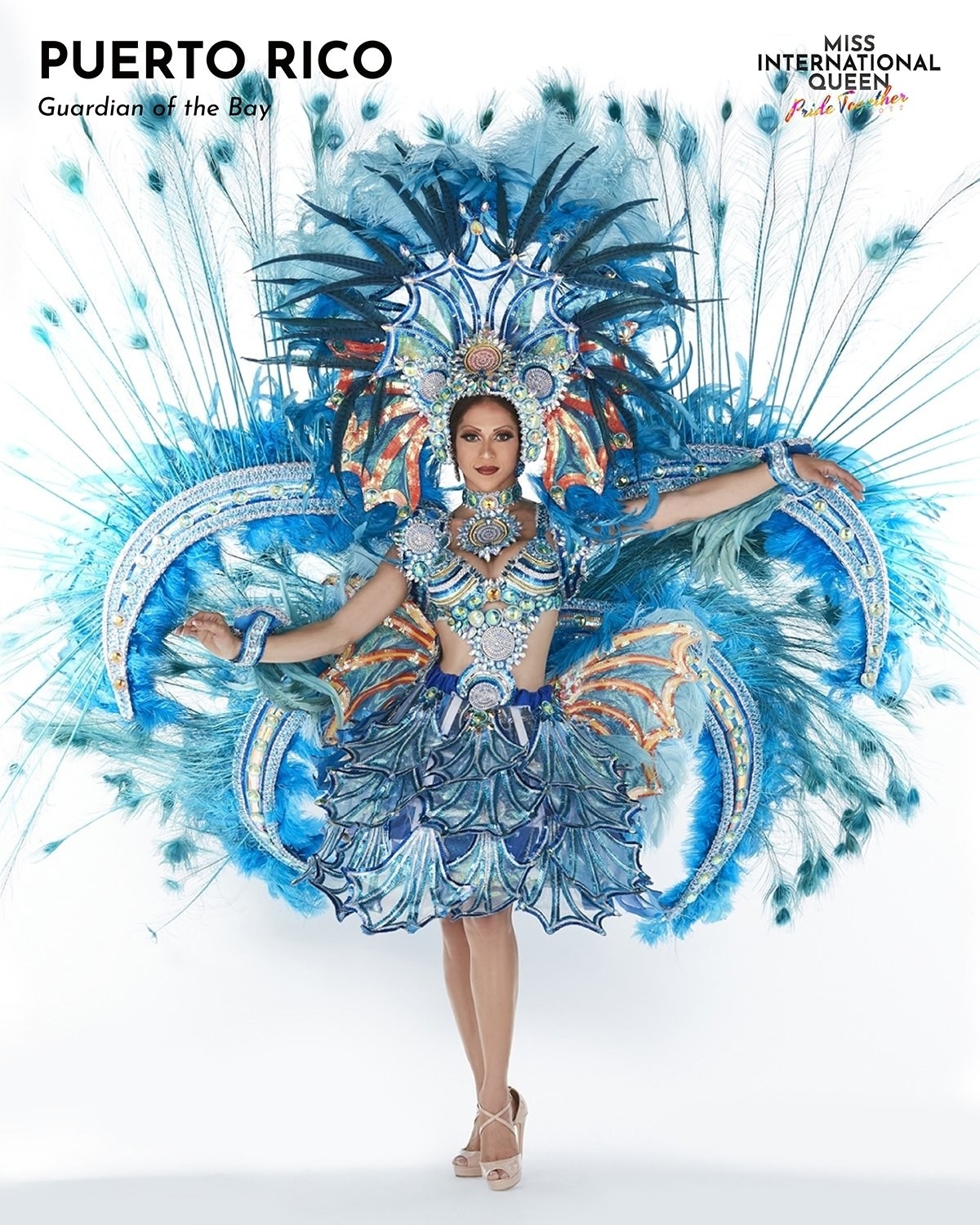 Miss Puerto Rico in an all-blue outfit with big feathers and a feather headpiece