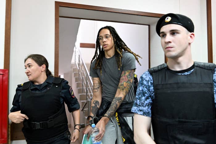 Brittney Griner wears handcuffs as she is escorted by two guards