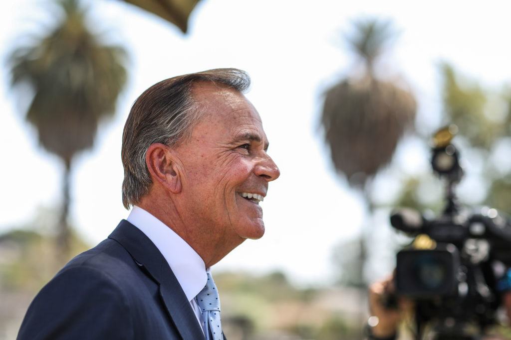 Rick smiling as he stands in front of cameras