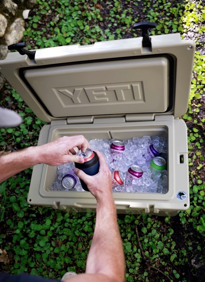 A person taking a can out of the Yeti cooler