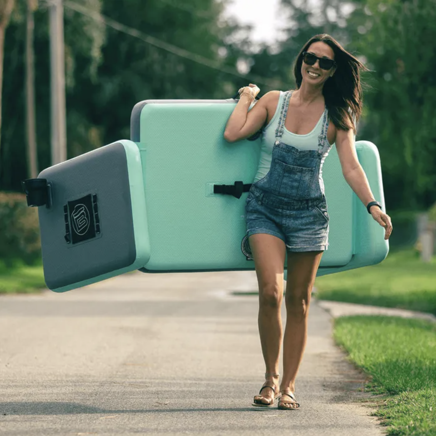 A person walking down a street carrying the couch