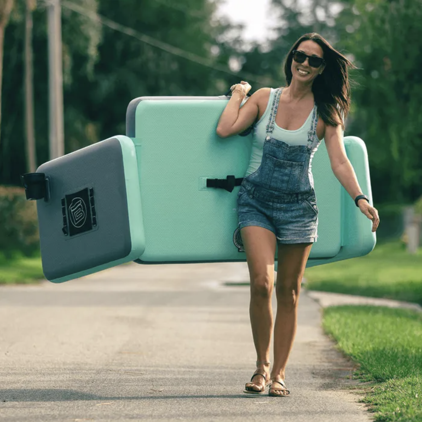 A person walking down a street carrying the couch