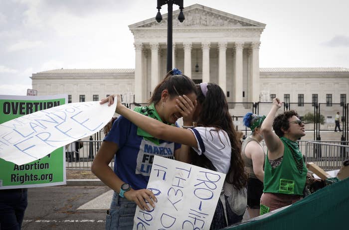 Abortion rights activists cry and comfort each other in front of the US Supreme Court in Washington DC