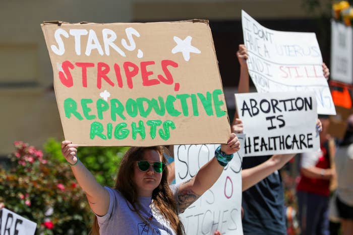 A woman holds a placard saying &quot;stars, stripes, reproductive rights&quot; during an abortion rights rally.