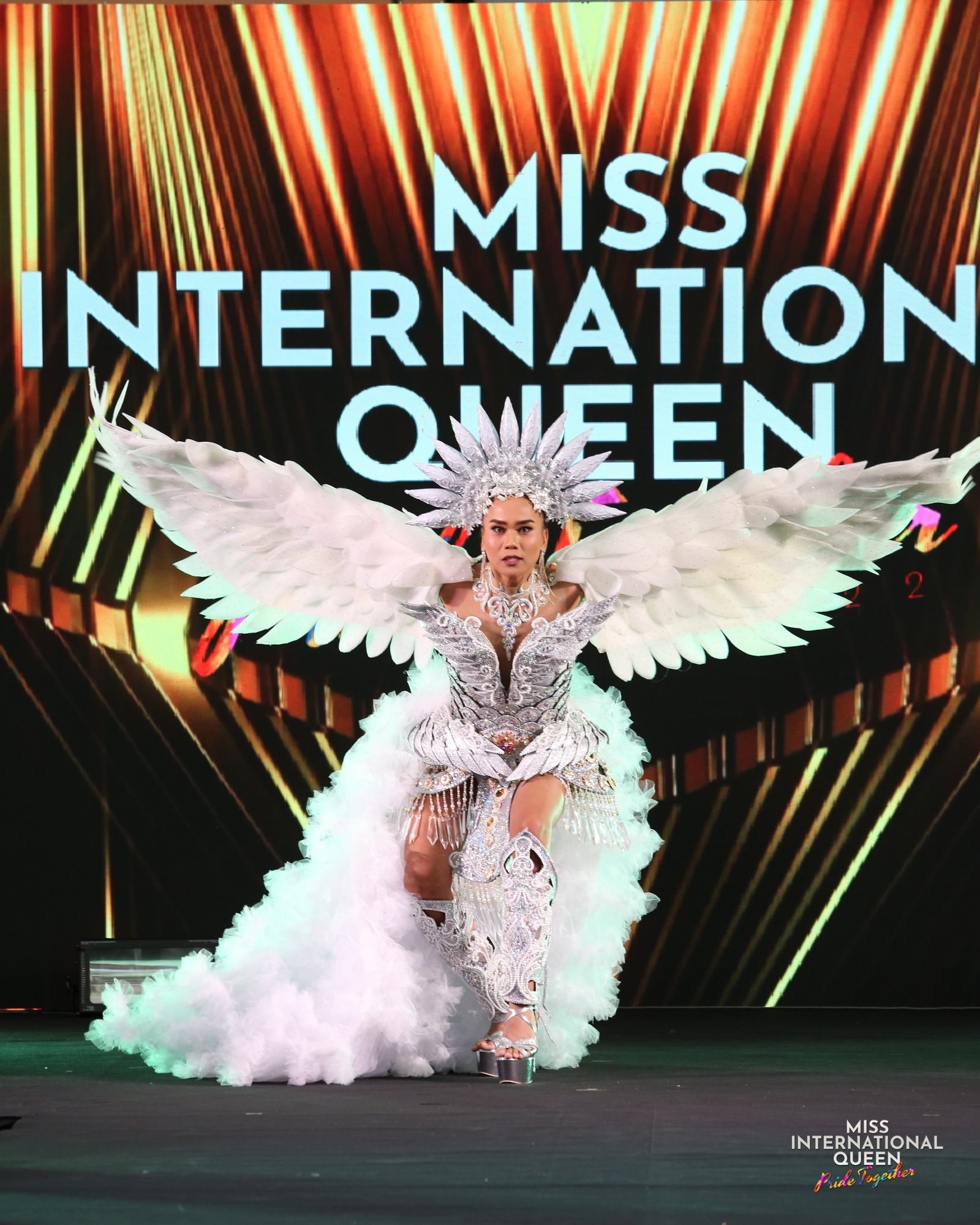 Miss Canada in the snow owl outfit raises her arms in a flying stance