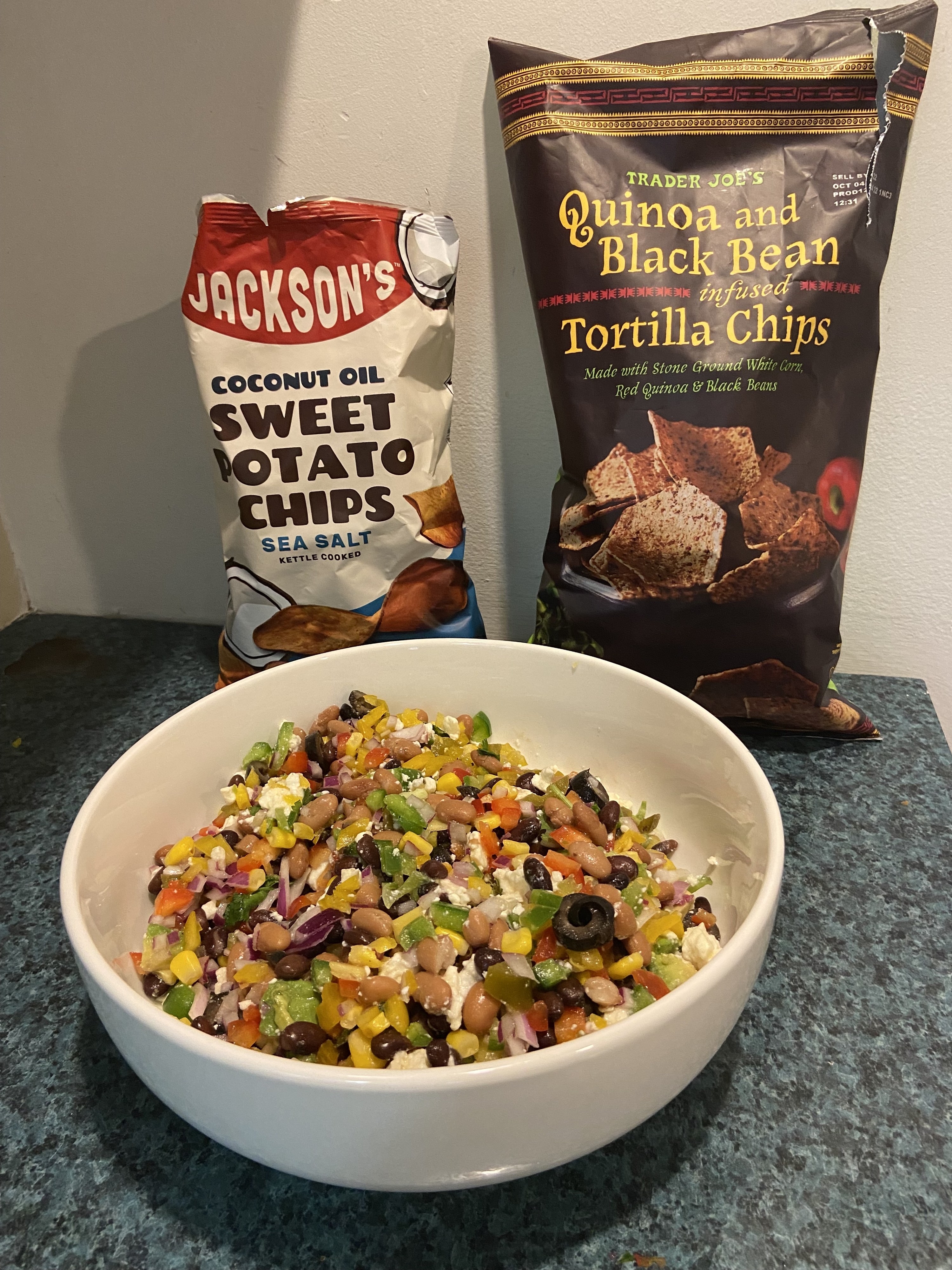 A bowl of Cowboy Caviar and two bags of chips