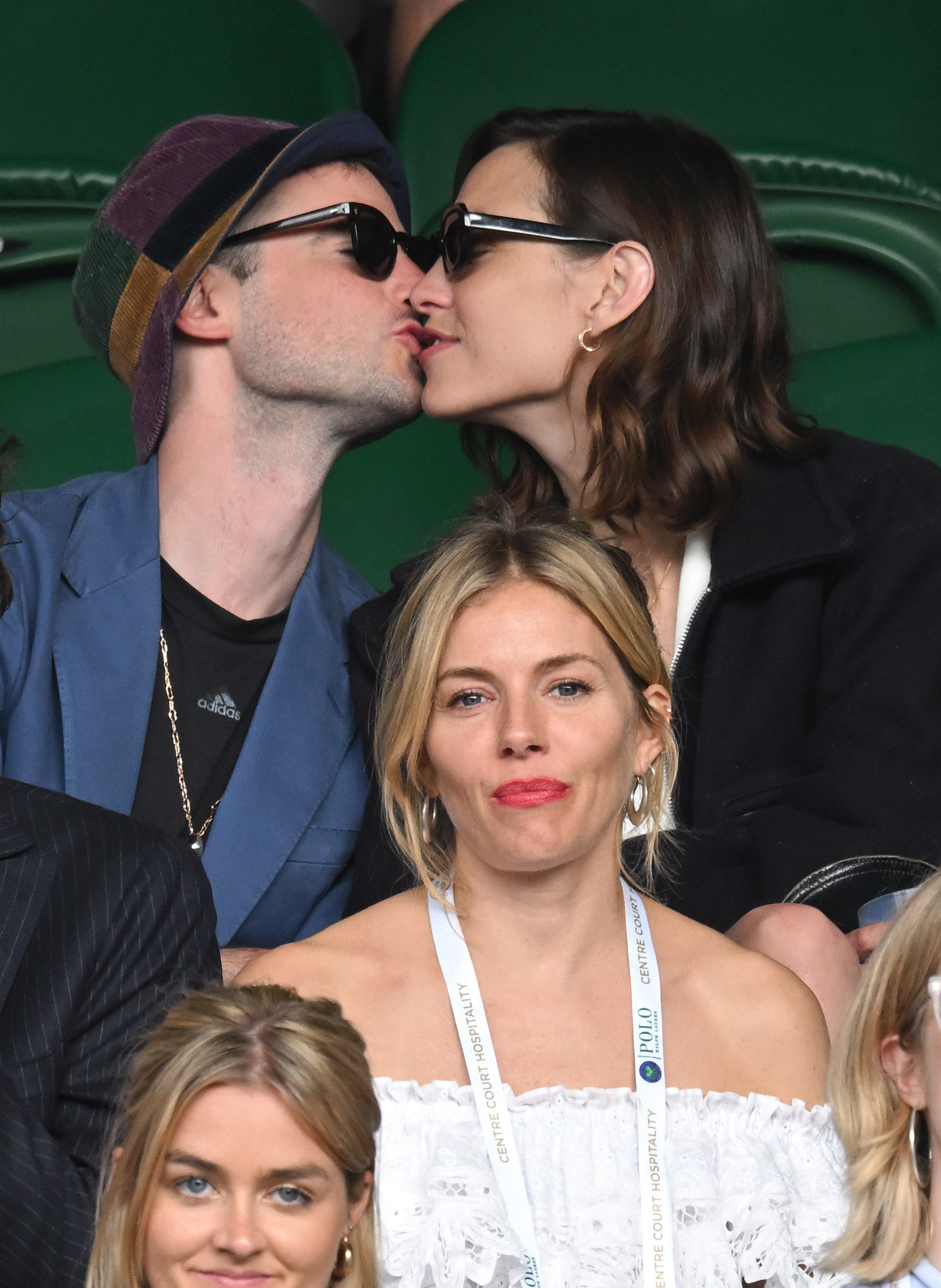Tom and Alexa share a kiss while Sienna sits in front of them