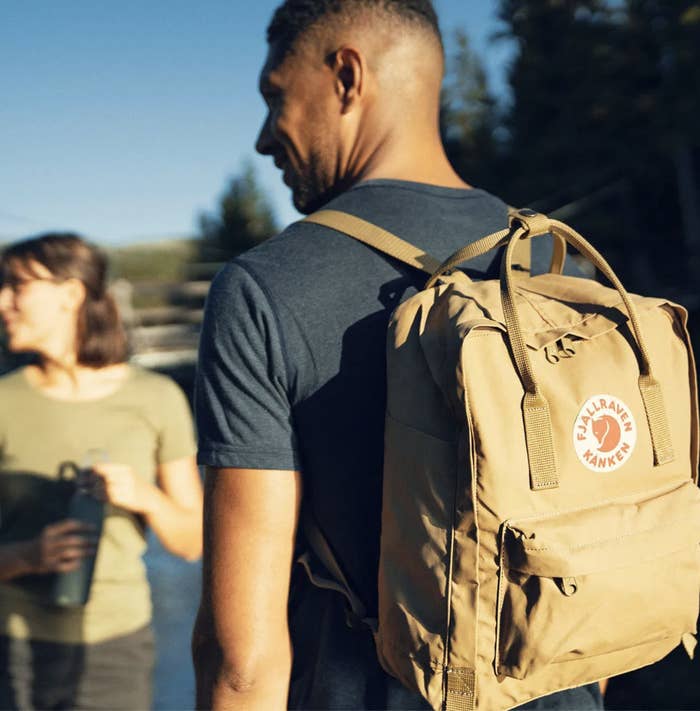 A person wearing a tee and the backpack