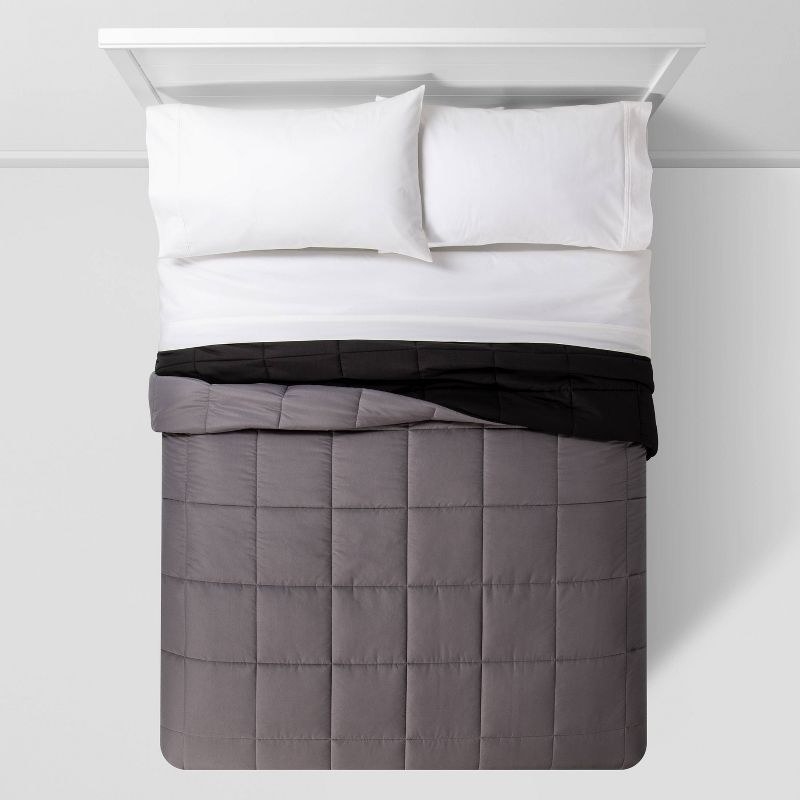 the comforter in black/dark gray on a bed