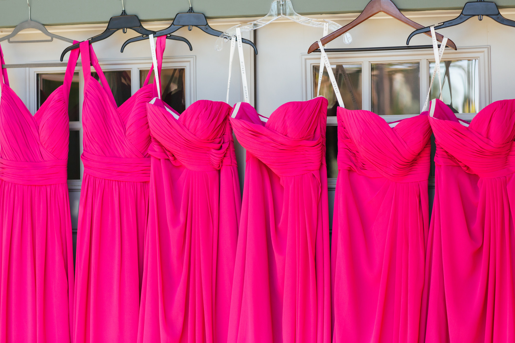 A row of pink dresses on hangers