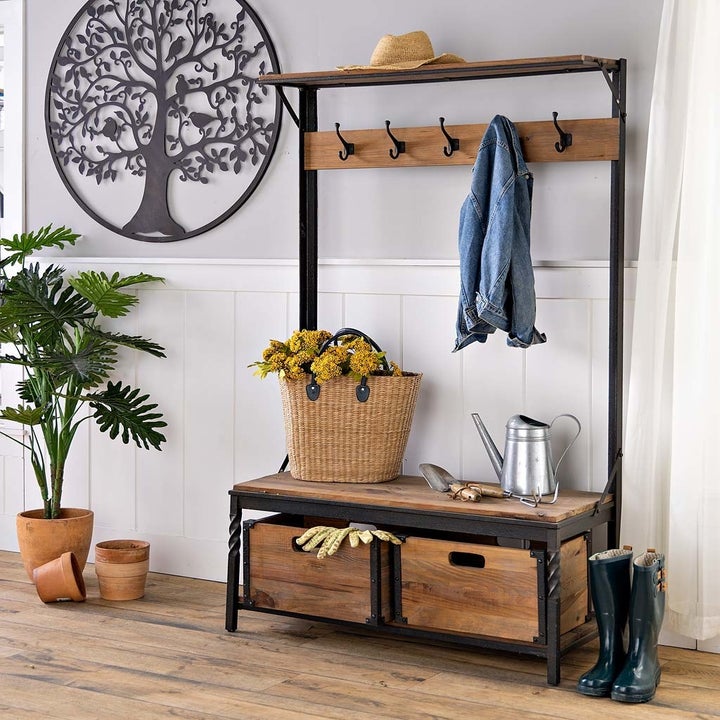 an iron and wooden coat rack with two under-bench storage drawers