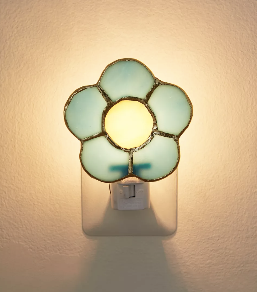 a flower-shaped stain glass nightlight plugged into the wall