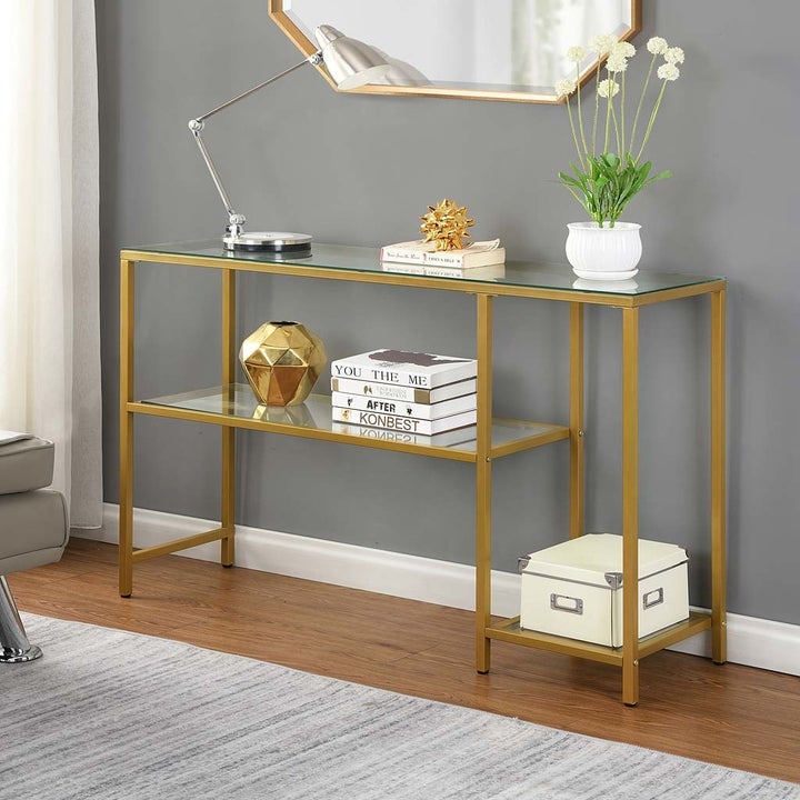 a gold and glass multi-shelved and tiered console table