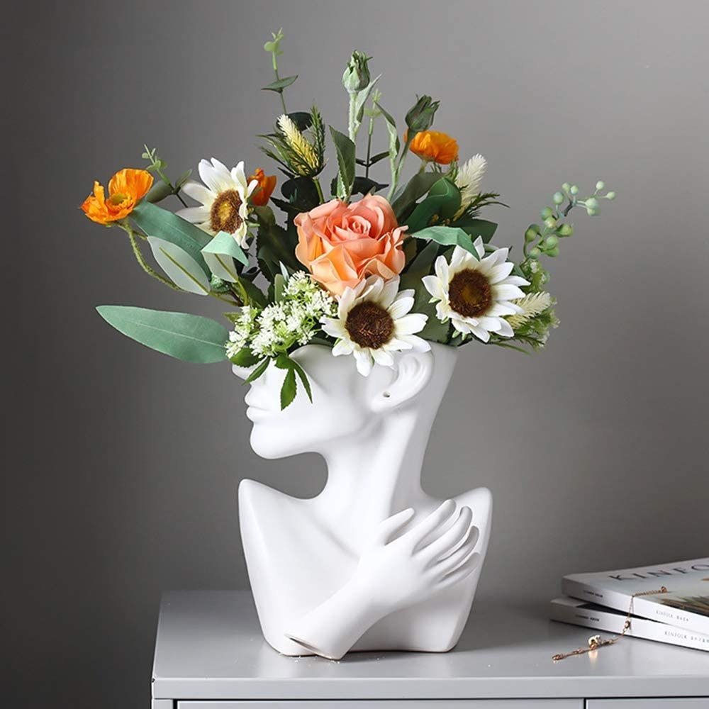 a vase shaped like a person&#x27;s face and chest