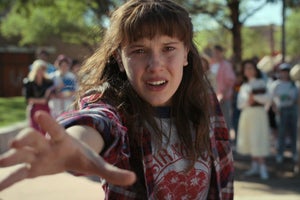 A close up of Will Byers wearing a flannel and Eleven with a spitball on her cheek