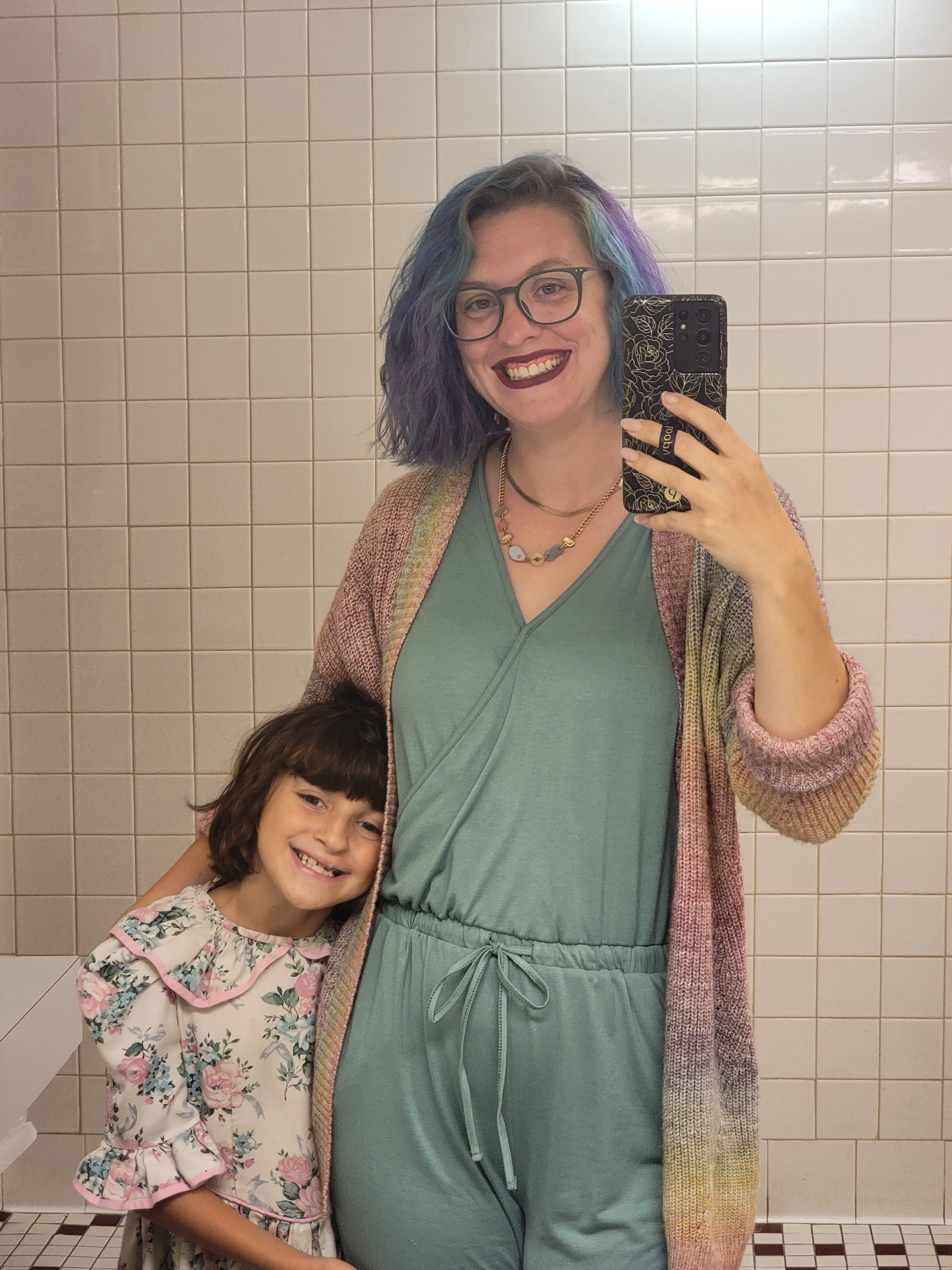 Brianna taking a mirror selfie with one of her children