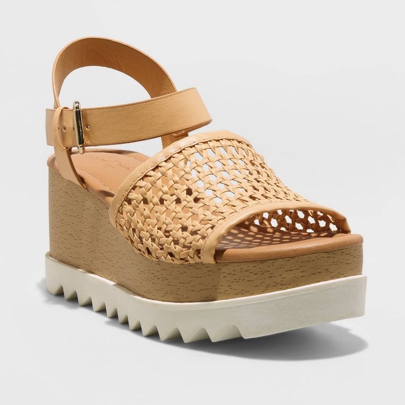 A pair of tan platform sandals with a white bottom
