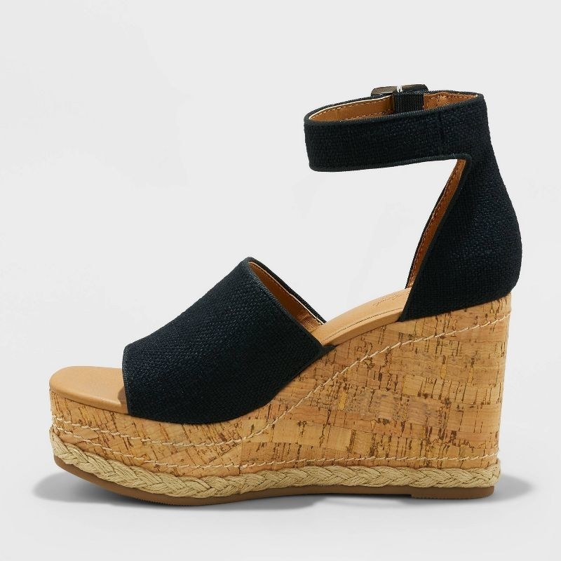 A pair of black and cork sandals with a braid detail on the bottom