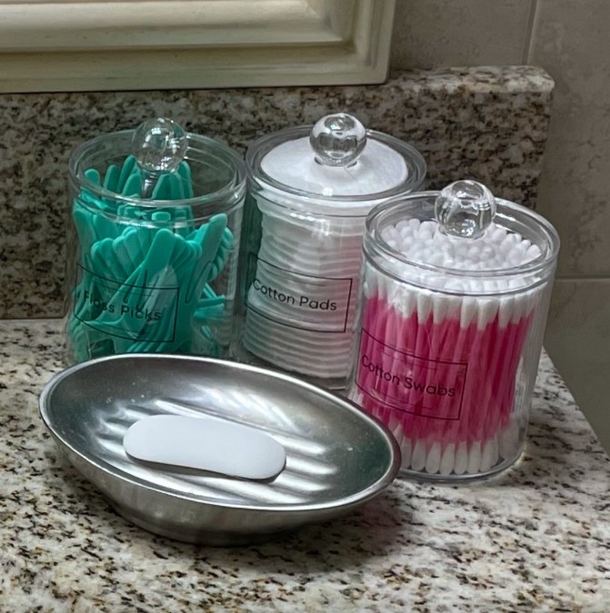 Reviewer image of canisters holding q-tips, cotton pads and floss picks next to a soap dish