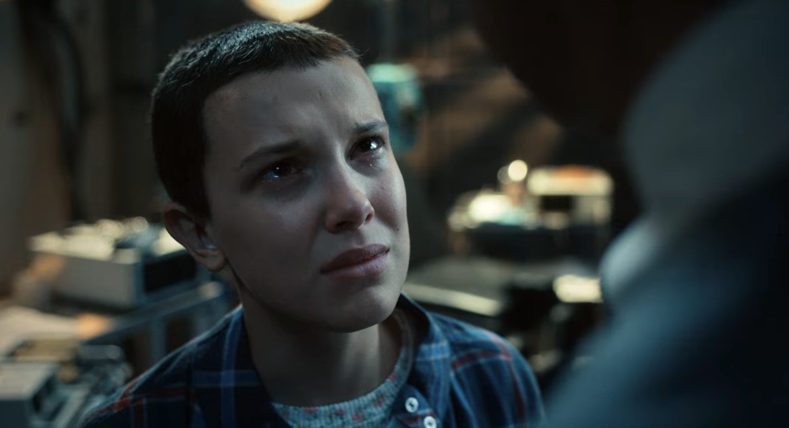 Eleven looking up at Dr. Brenner in "Stranger Things"