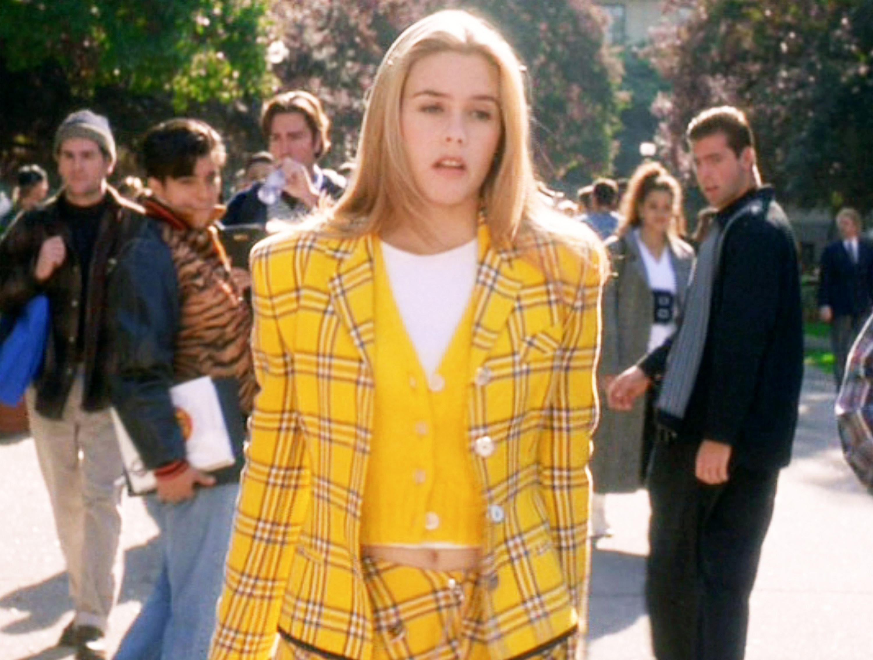 Alicia Silverstone as Cher walks around campus in a yellow co-ord outfit in &quot;Clueless&quot;