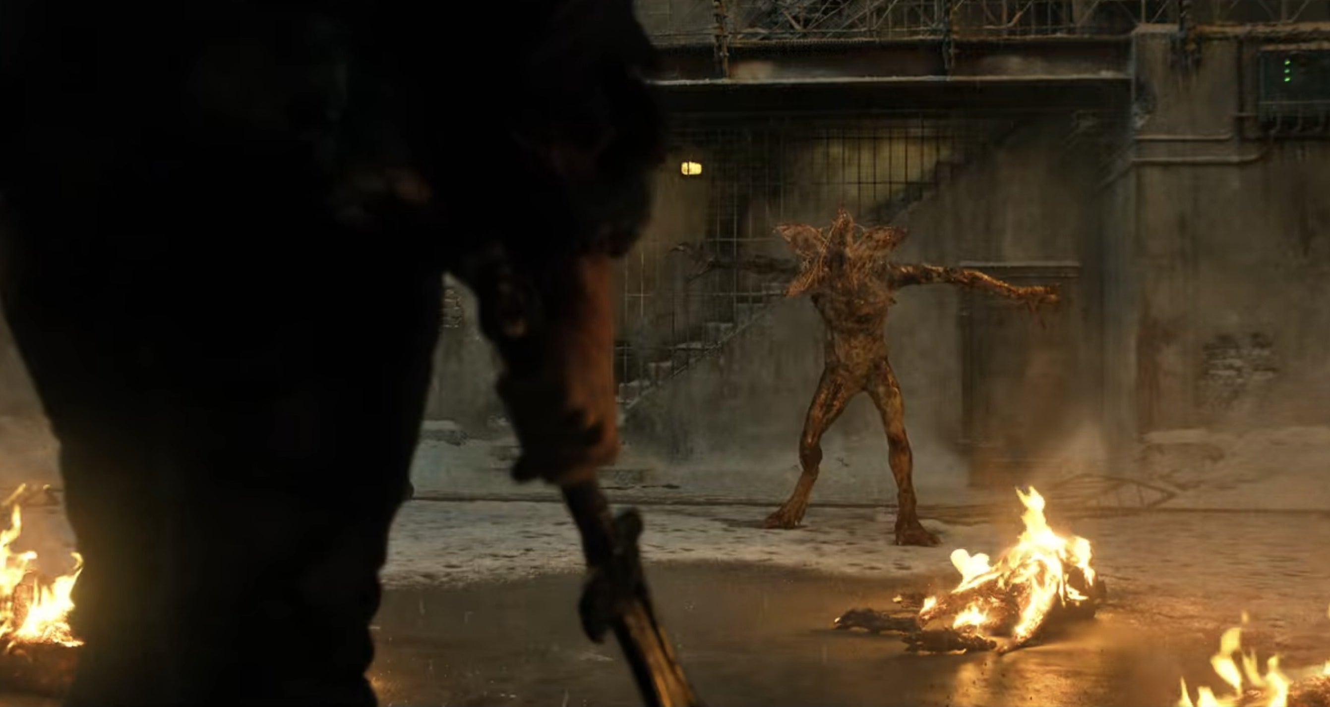 Hopper holding a sword in front of a Demogorgon