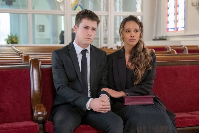 A guy and girl holding arms at a funeral