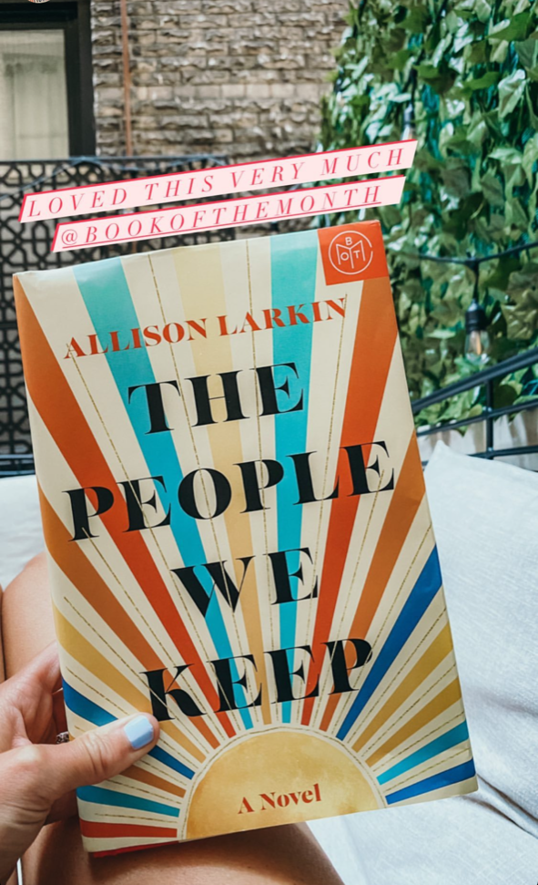 A person holding "The People We Keep" by Allison Larkin.
