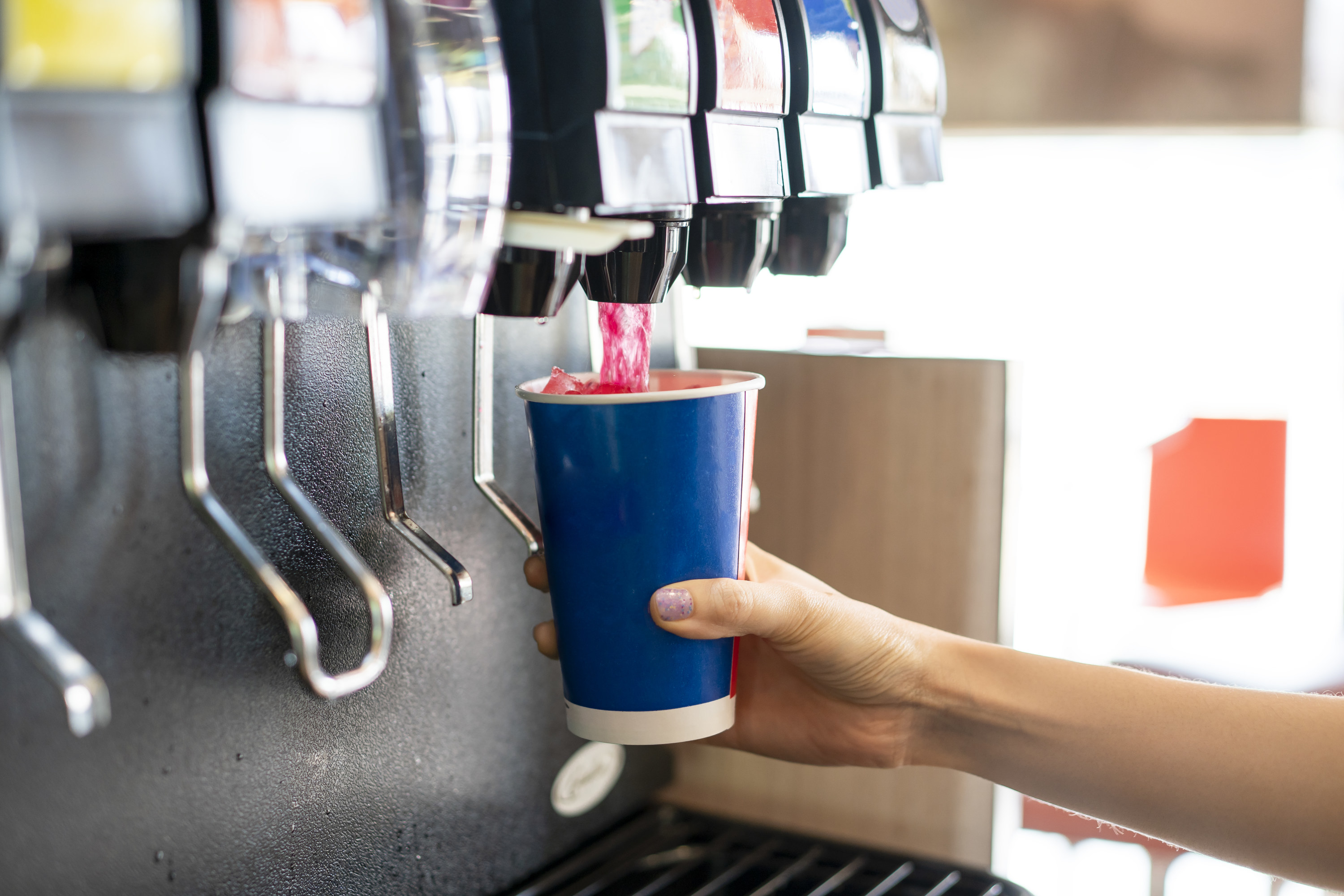 someone filling their cup from drink machine