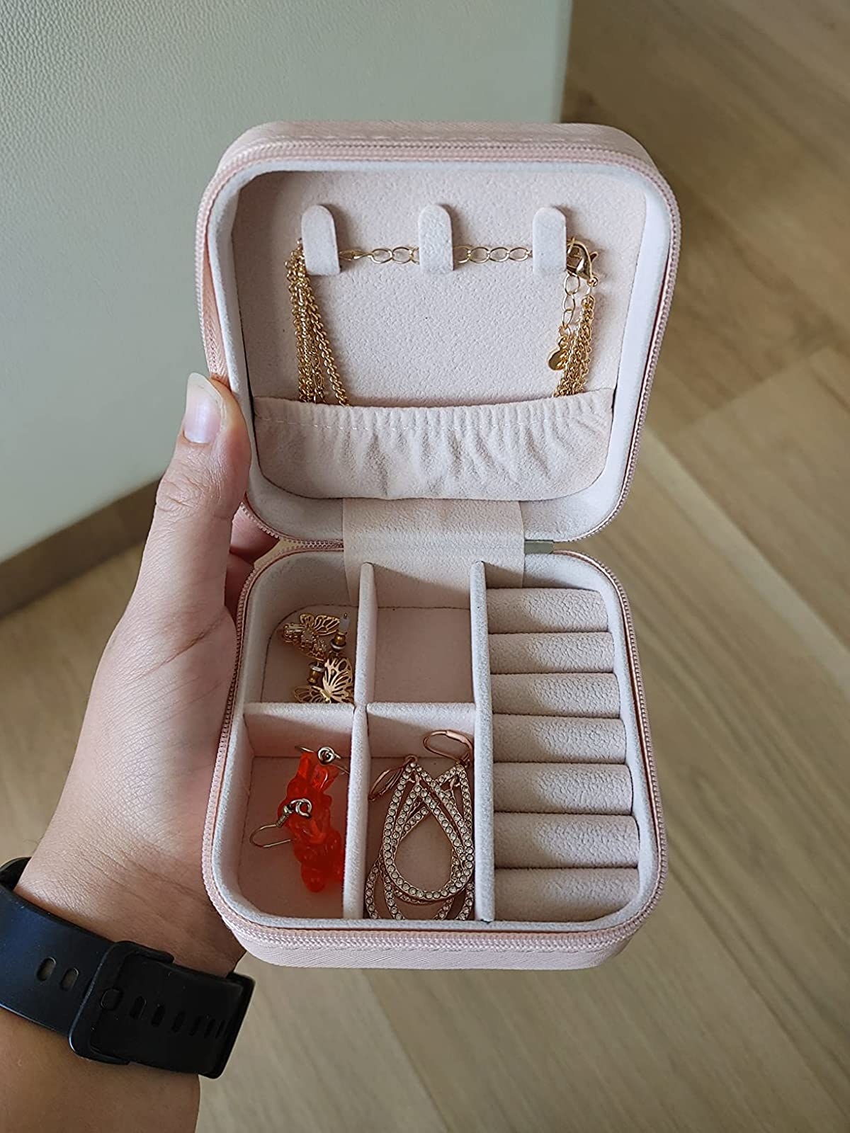 Reviewer holding pink travel jewelry holder