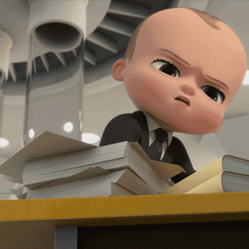 A baby is throwing papers off of a table