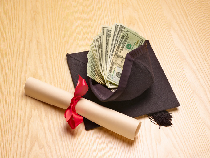 A wad of cash next to a diploma