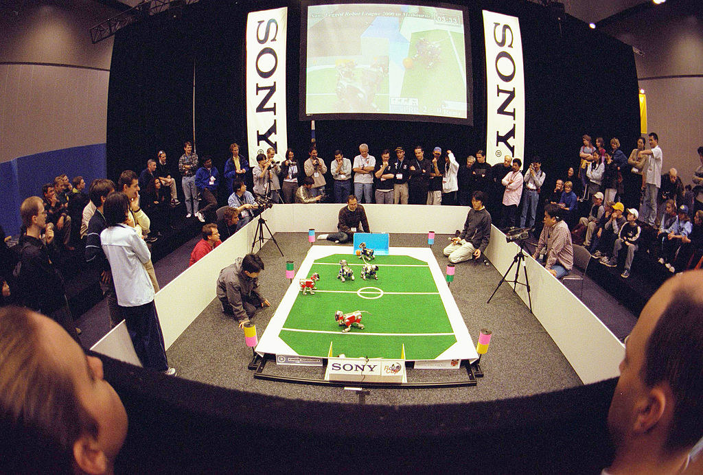 an audience circling a robot competition