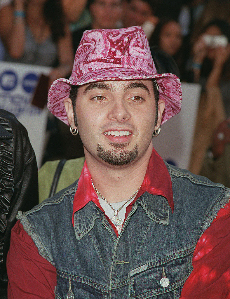 an nsync member in a jean vest over a button-down and a paisley cowboy hat