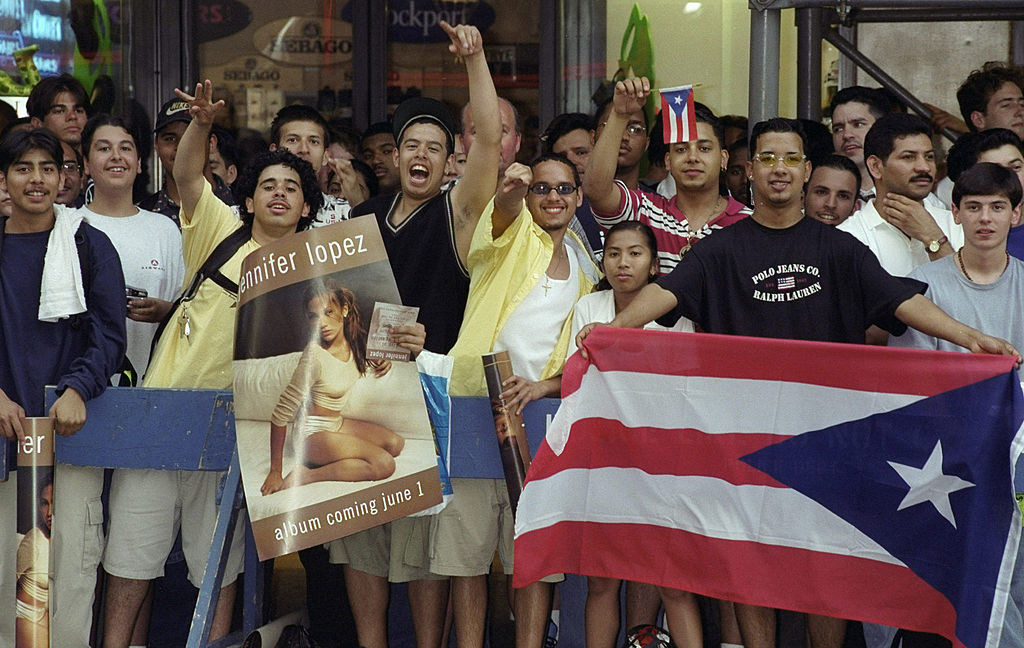 fans on the street holding j.lo signs