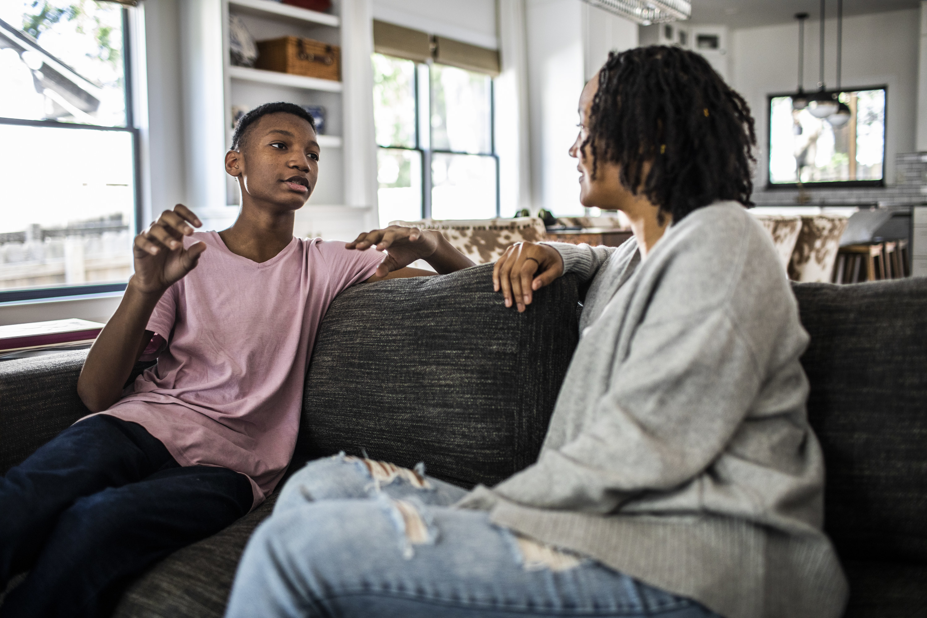 Mother and son having a conversation on a sofa at home