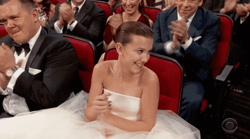 Millie Bobby Brown sitting in an audience and clapping