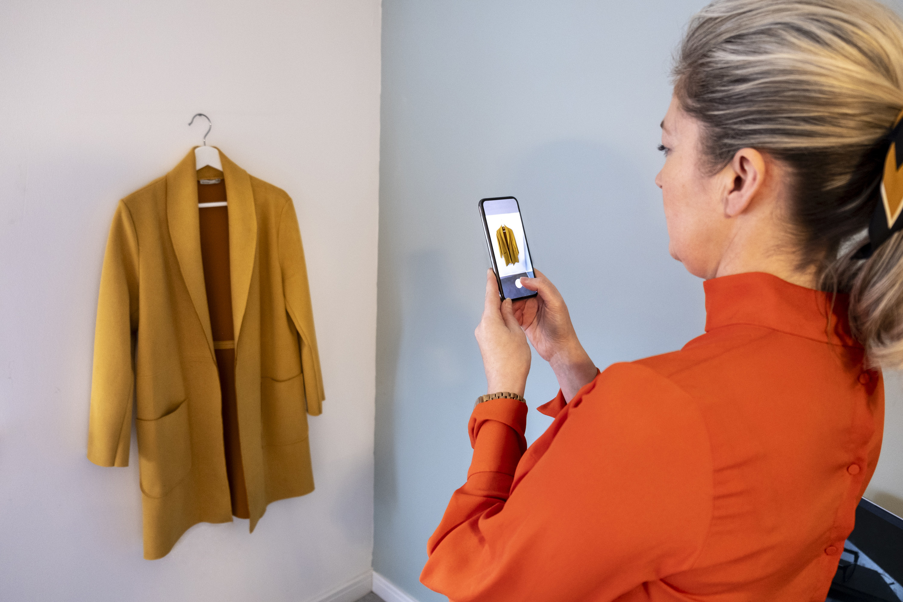 woman photographing old clothes to sell online