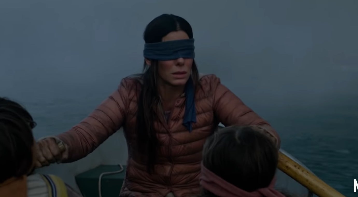 Malorie blindfolded and rowing a boat with Boy and Girl in &quot;Bird Box&quot;