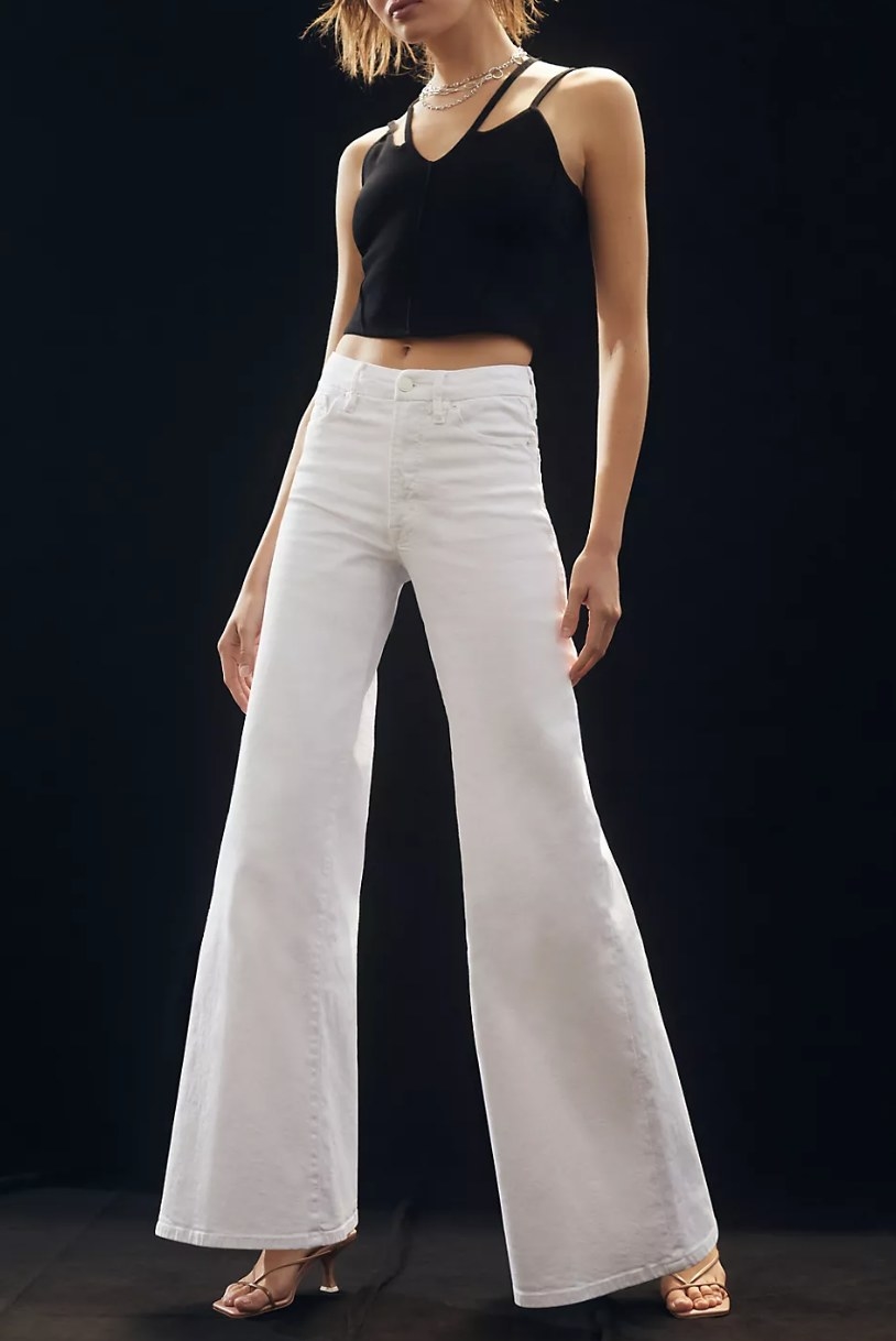 a model wearing the white denim jeans