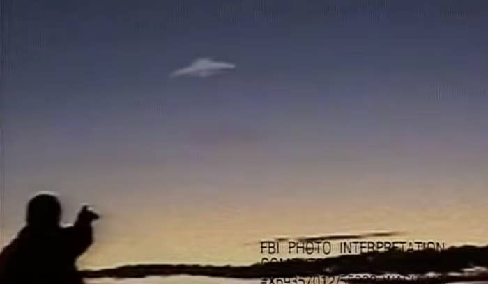 A man points at a UFO in the sky