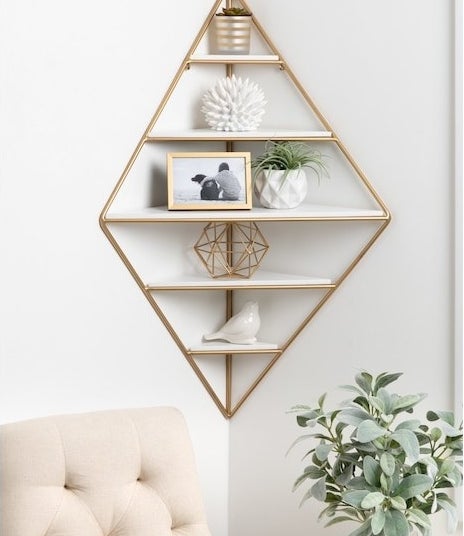 the white and gold diamond shaped shelf mounted in a corner