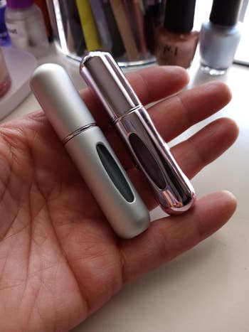 a reviewer hold a pink and silver atomizer