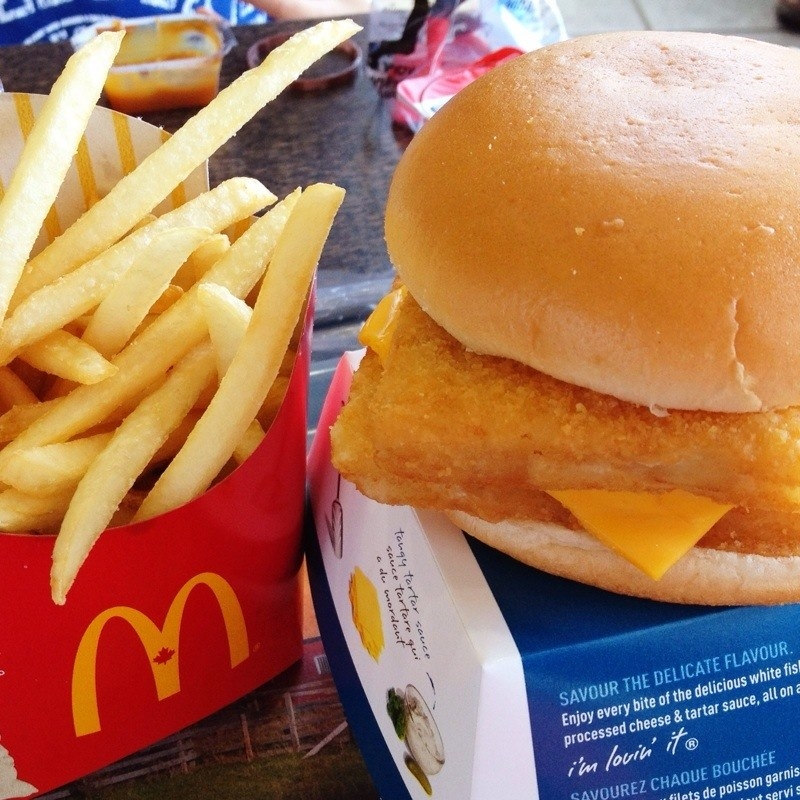 A McDonald&#x27;s order with chips and a Filet-O-Fish burger resting on top of its box