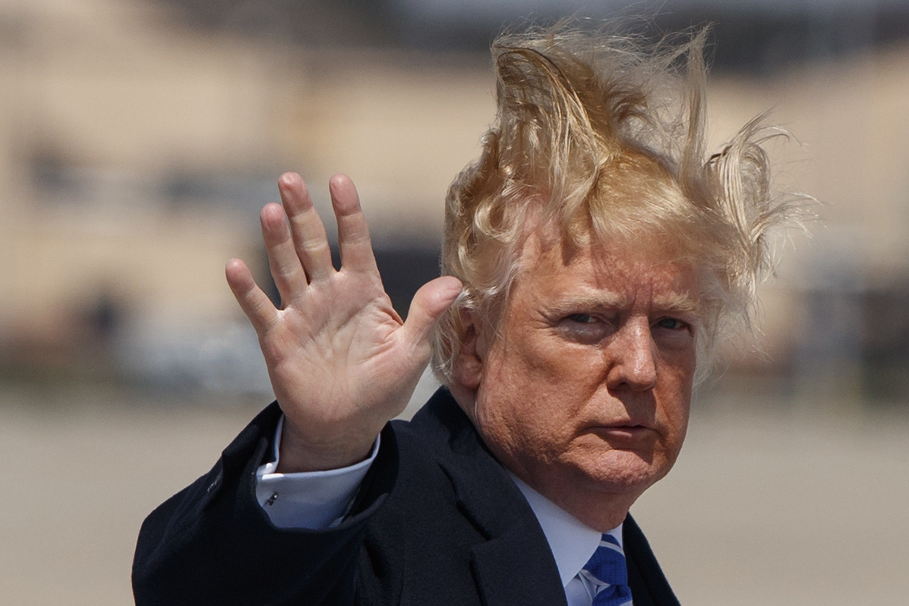 Donald Trump is seen with windswept wild hair as he waves at the cameras