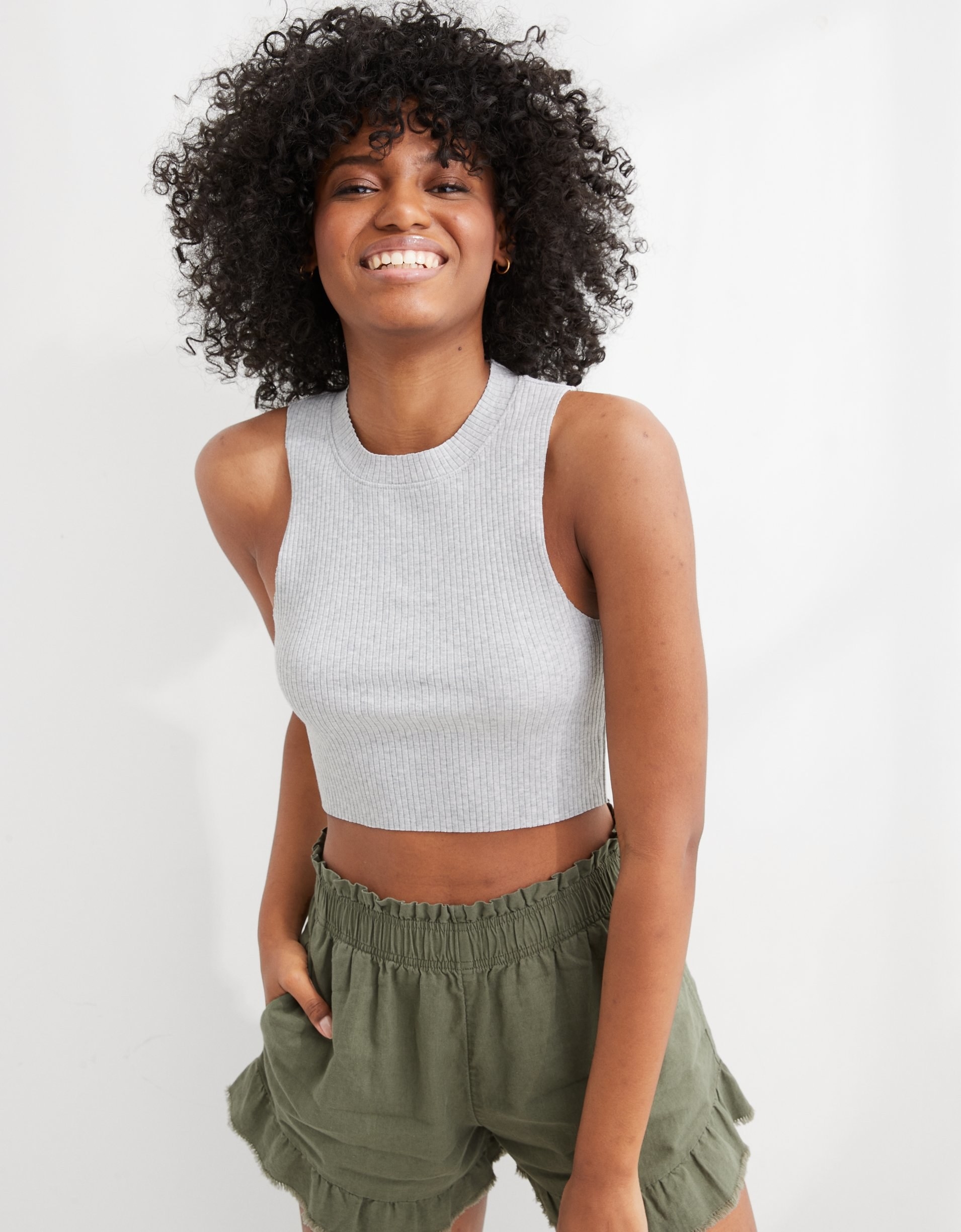 model in cropped ribbed tank with wide straps and a high neck