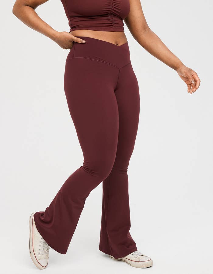 model in dark berry flare leggings with a cross-front waistband