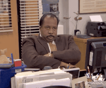 Stanley from Office  with his arms cross and looking fed up
