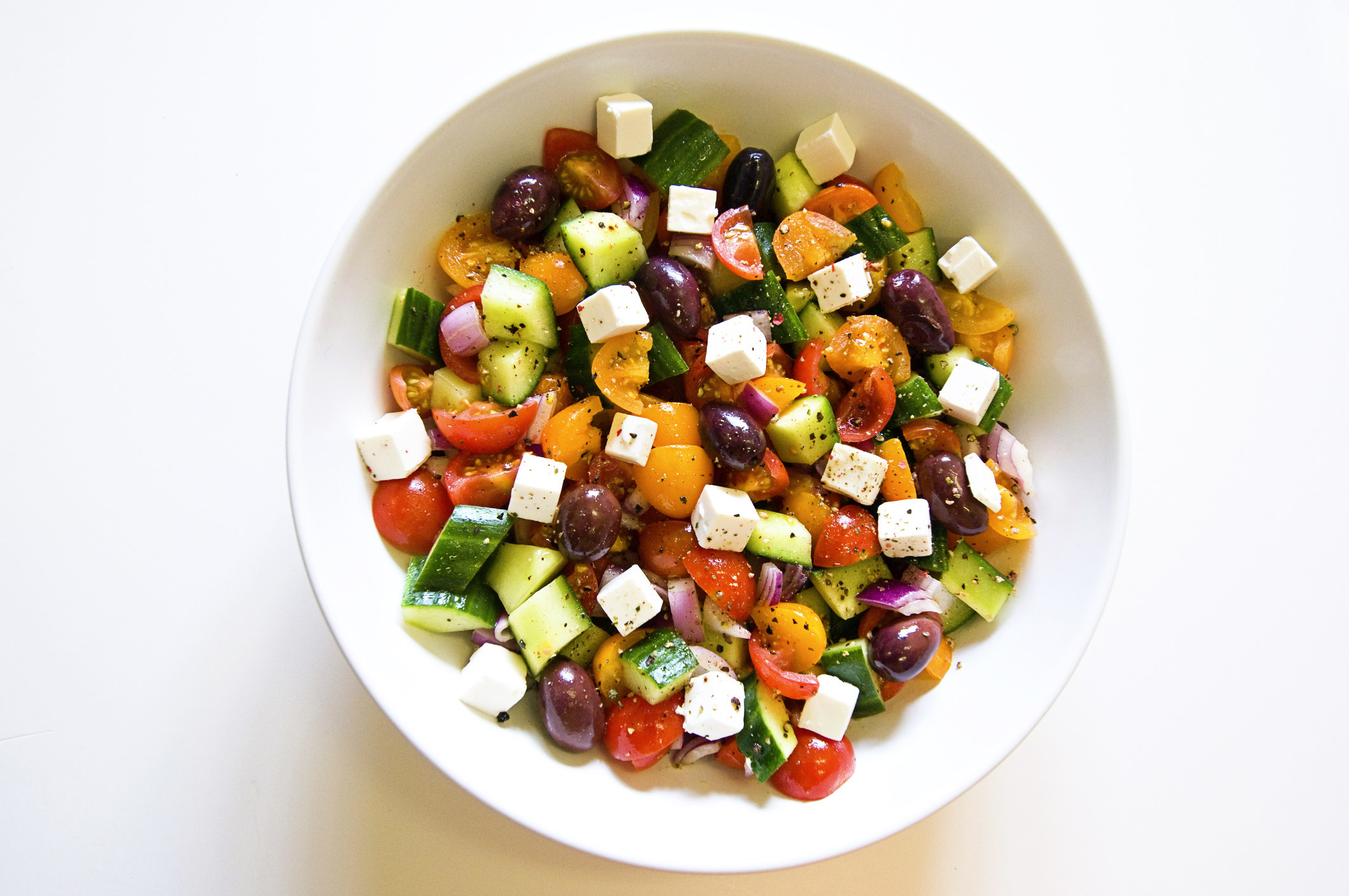 Greek salad, including tomatoes, cucumber, olives, onions and feta cheese.