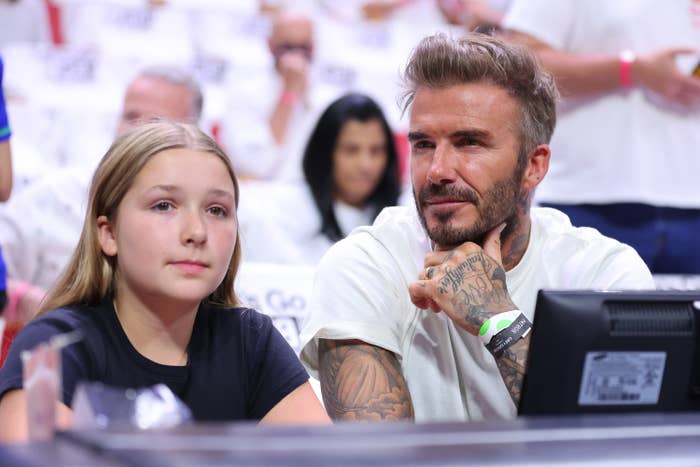 Harper sits next to her dad David at an event